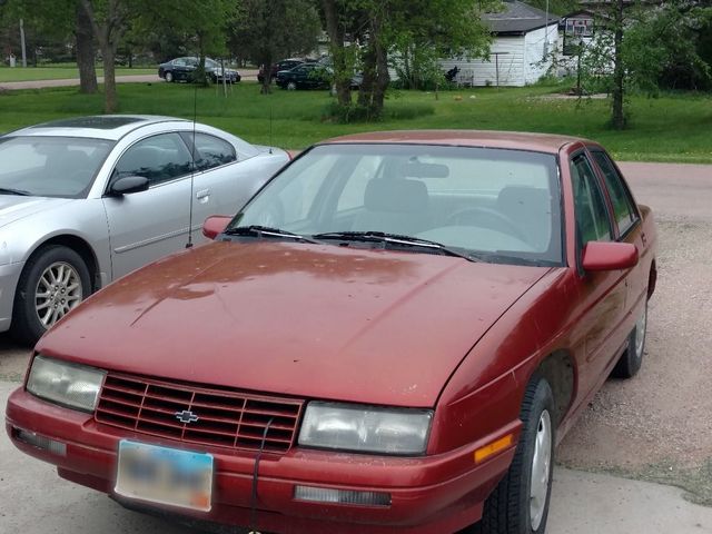 1996 Chevrolet Corsica Base, Medium Garnet Red Metallic (Red & Orange), Front Wheel